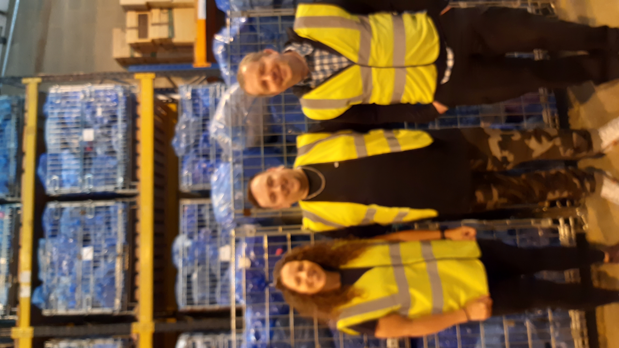 3 people in high vis jackets in a warehouse